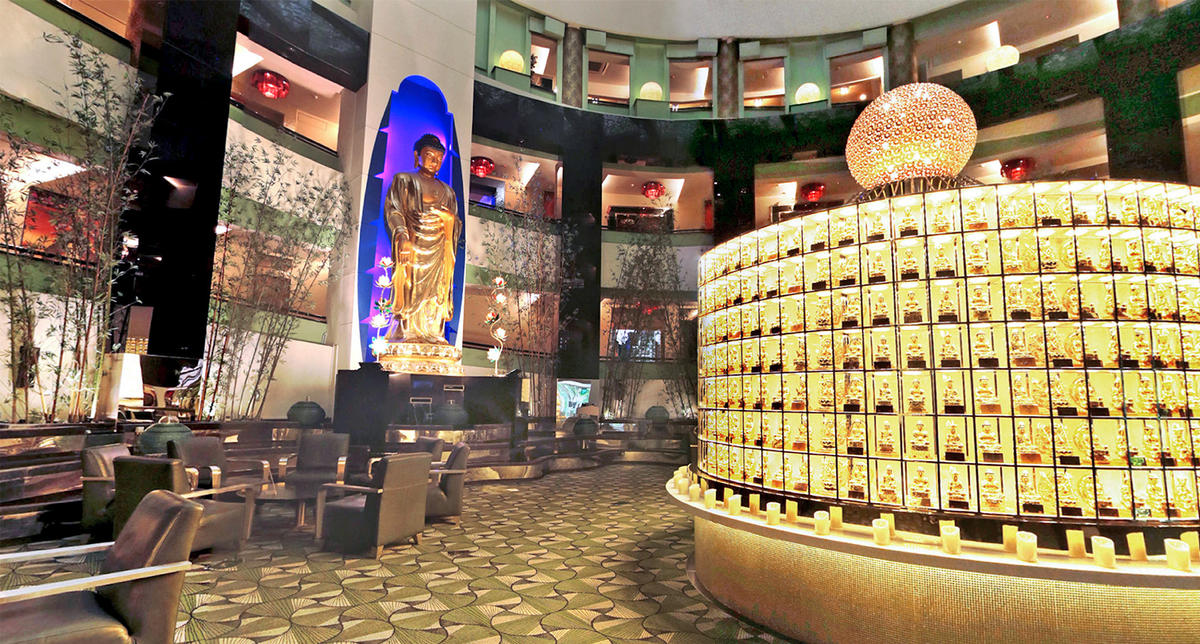 Buddha statue and illuminated memorial displays in a peaceful hall