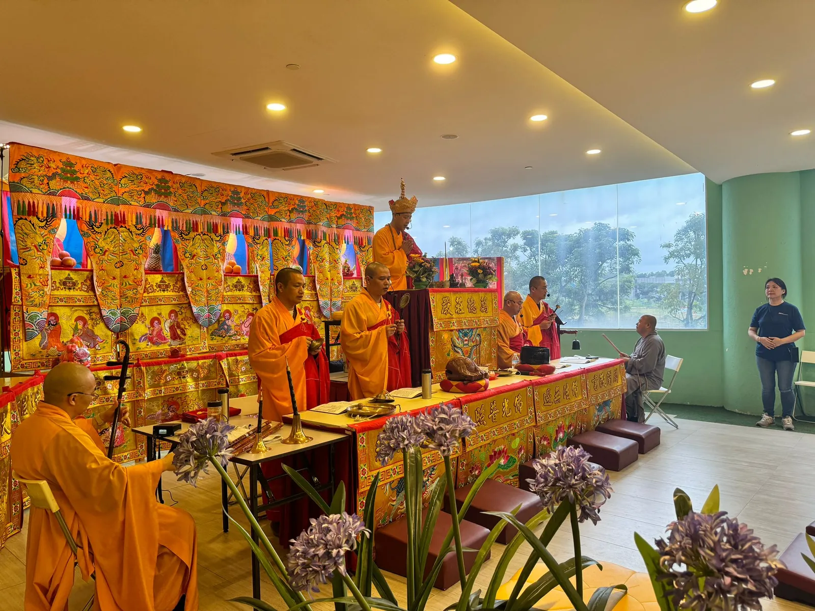 Buddhist monks conducting a prayer ceremony with flowers and offerings